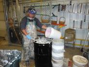 5 gallon paint buckets are combined into 55 gallon drums for recycling