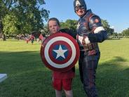 Boy posing with Captain America and his shield.