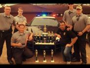 Officers Pose In Front Of Trophies