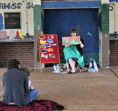 Woman in green dress reading to family